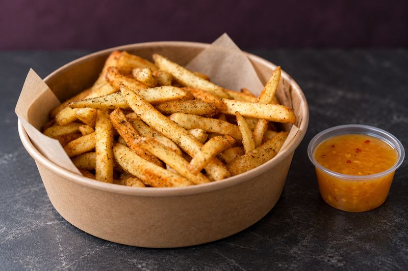 Seasoned fries with a cup of SISIN Gold